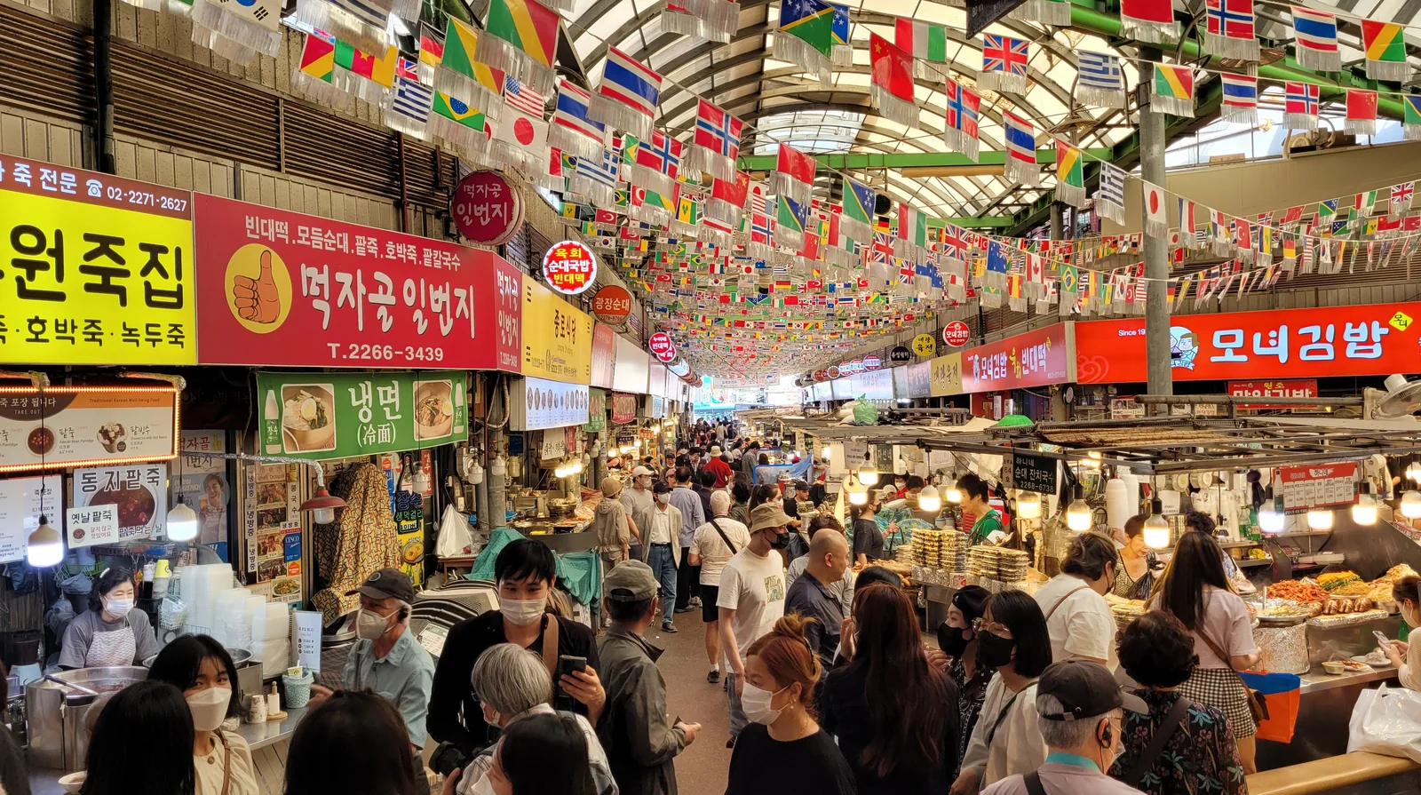 Busy food stalls and visitors inside Gwangjang Market in Seoul