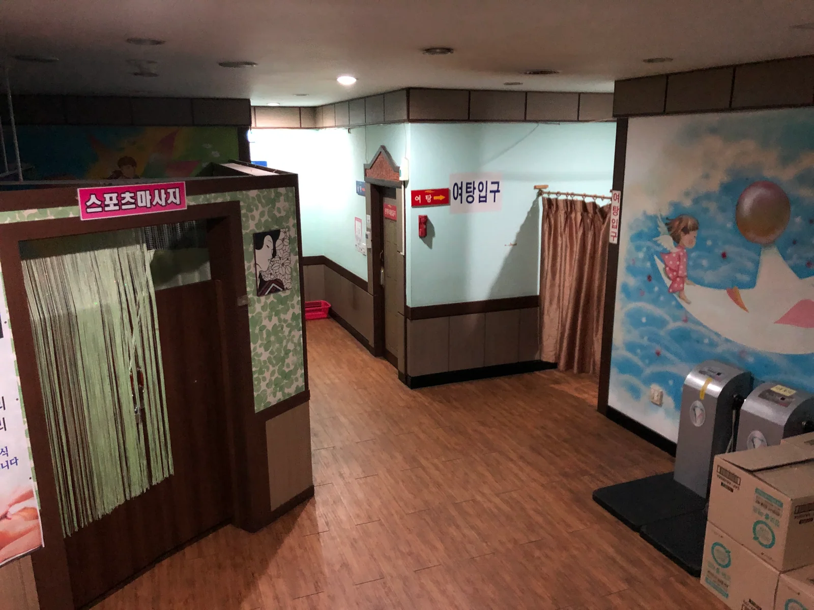 Interior corridor of a South Korean jjimjilbang with massage room and bath-area signs
