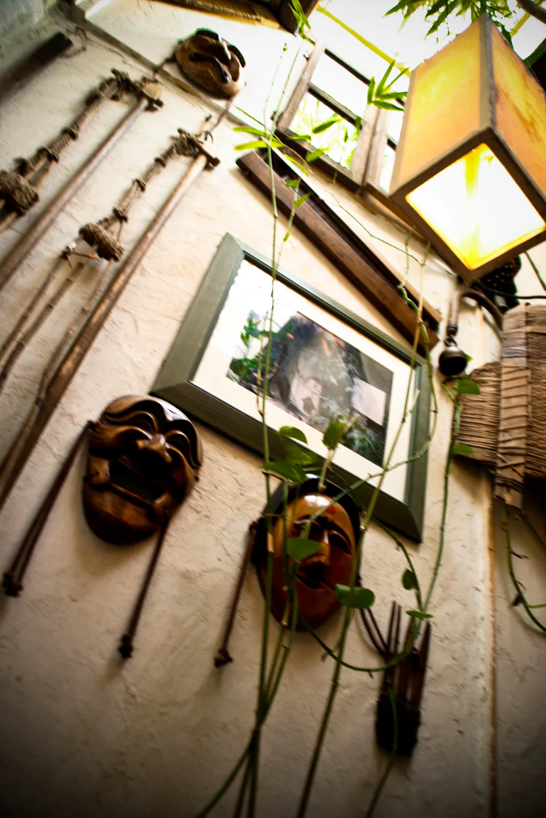 Interior detail of a Korean tea house with traditional masks, climbing plants, and warm lantern light