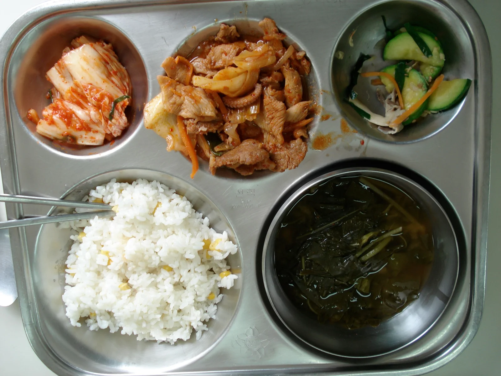 A South Korean school lunch on a compartment tray with rice, soup, and several side dishes